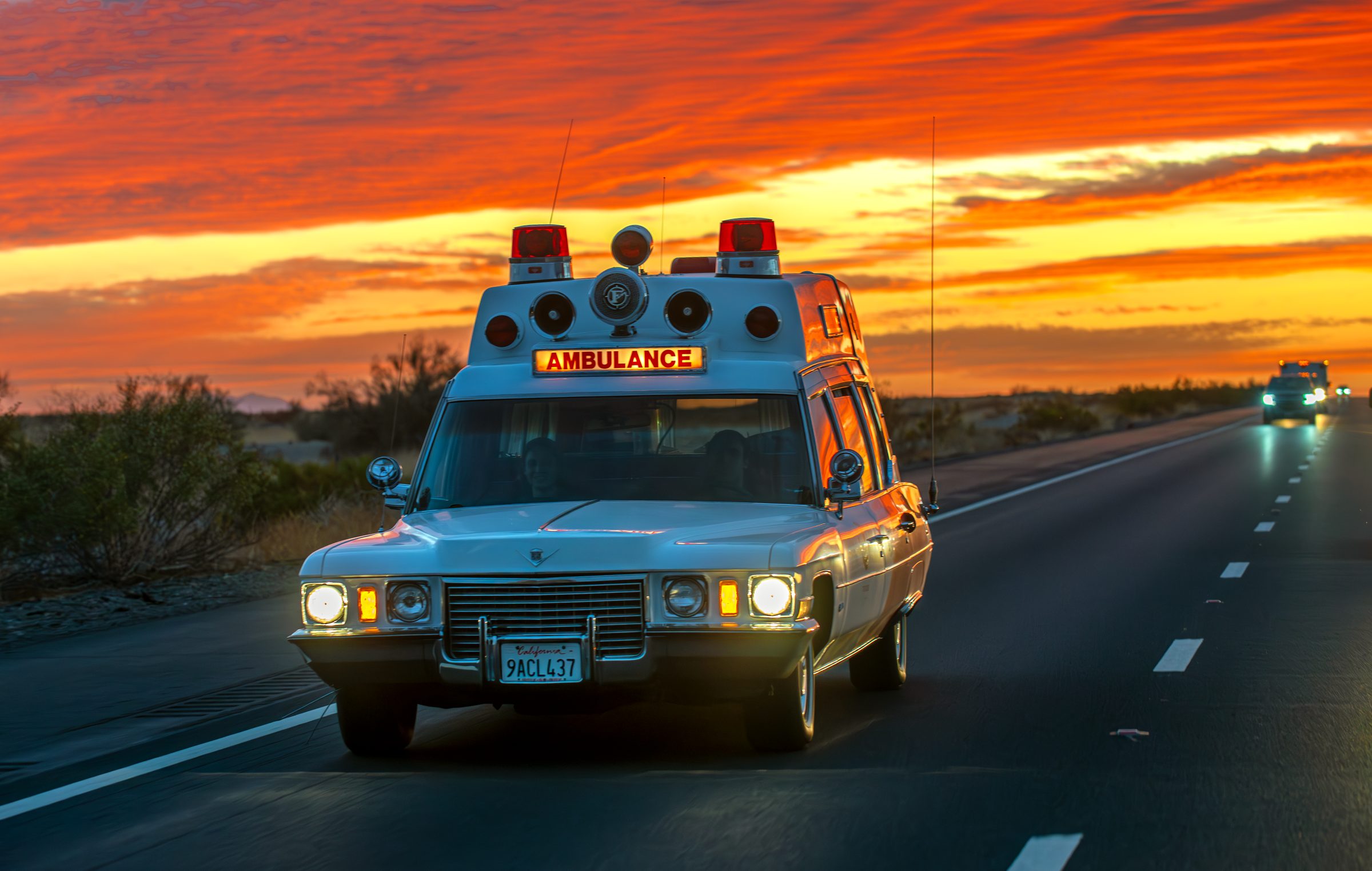 Vintage Symbiosis Cadillac ambulance driving at sunset