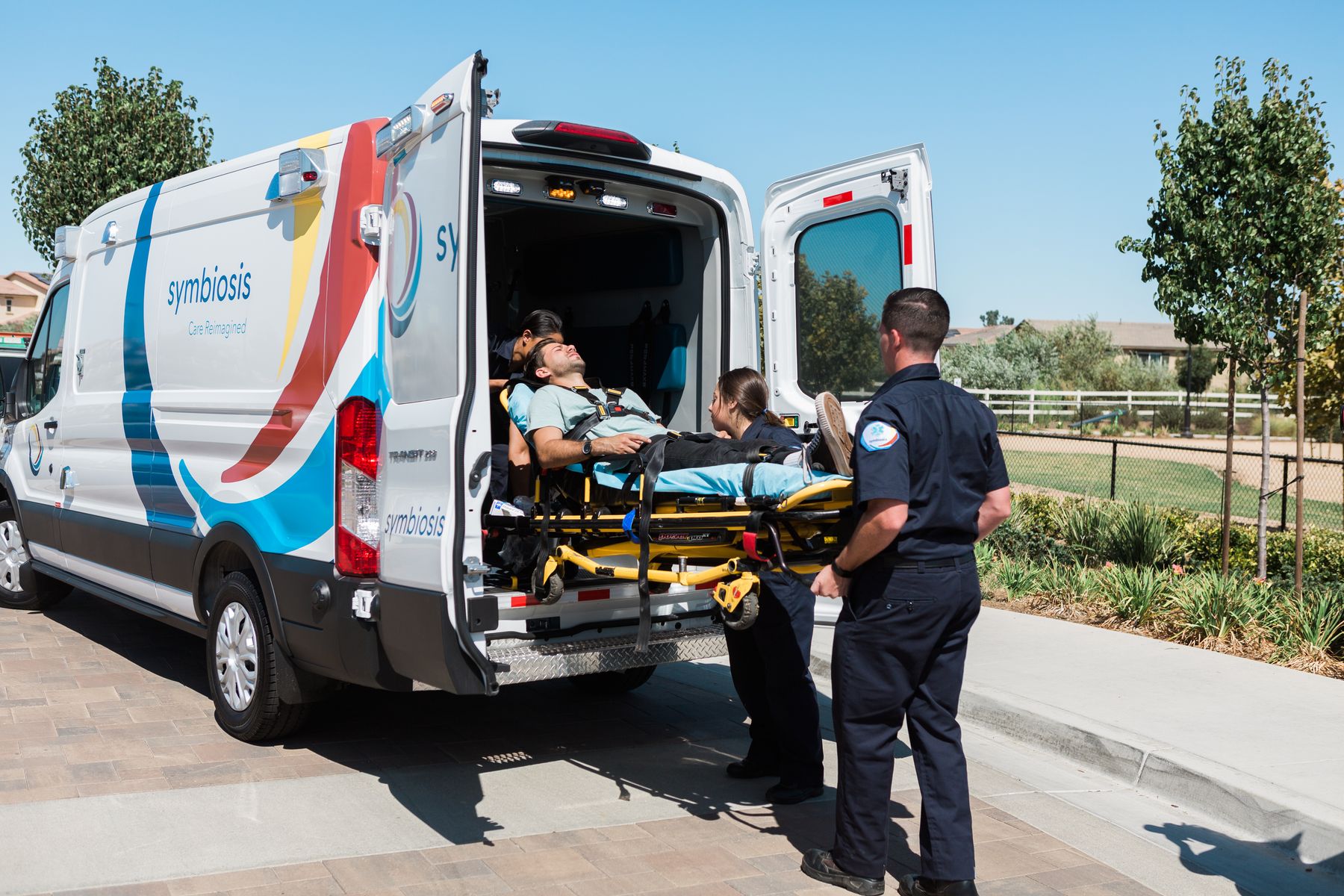 Symbiosis EMTs loading a patient into an ambulance