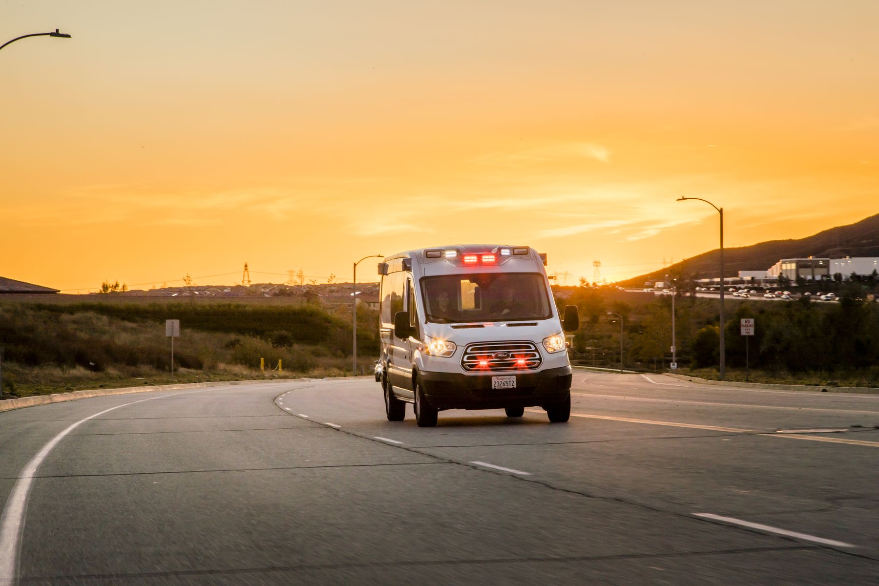 Symbiosis ambulance responding at sunset with emergency lights on