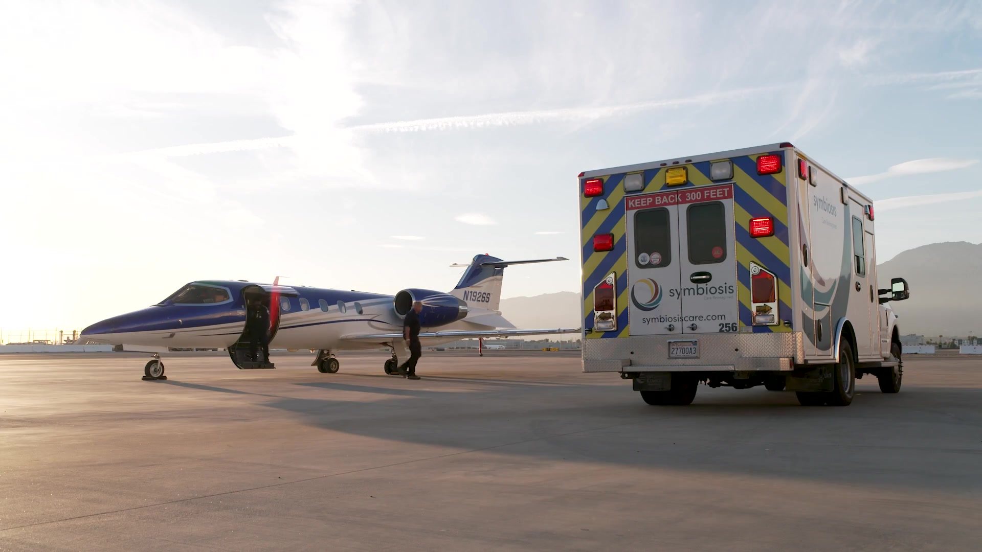 Symbiosis fixed-wing air ambulance jet and ground ambulance on the tarmac